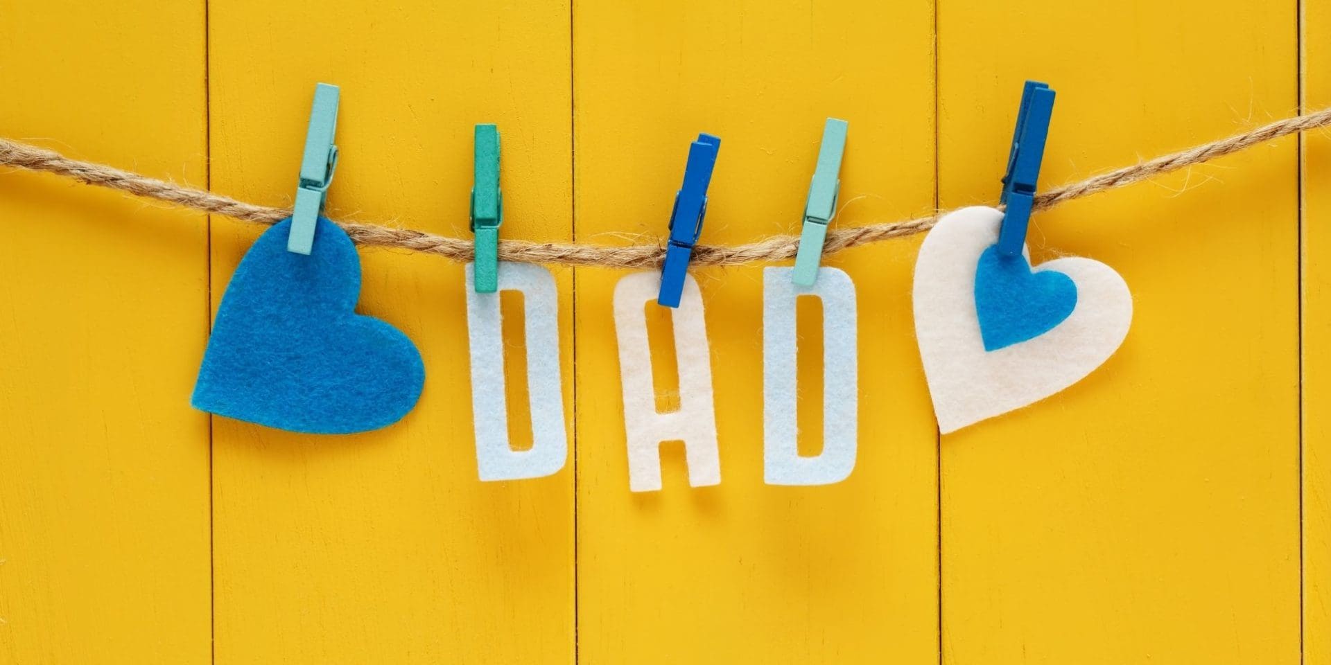 Felt letters spelling dad pegged to a string