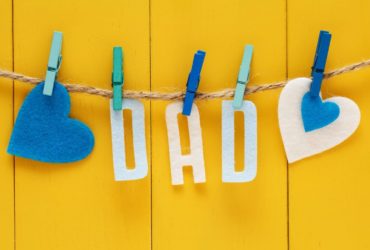 Felt letters spelling dad pegged to a string