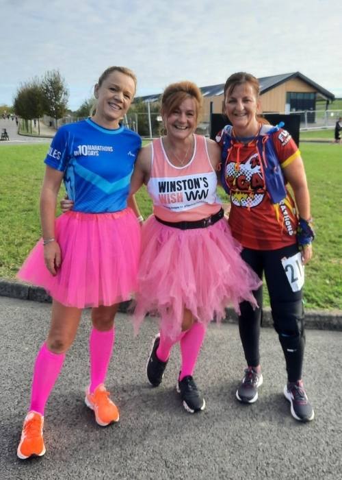 marie and 2 friends running her 100th marathon in pink tutus