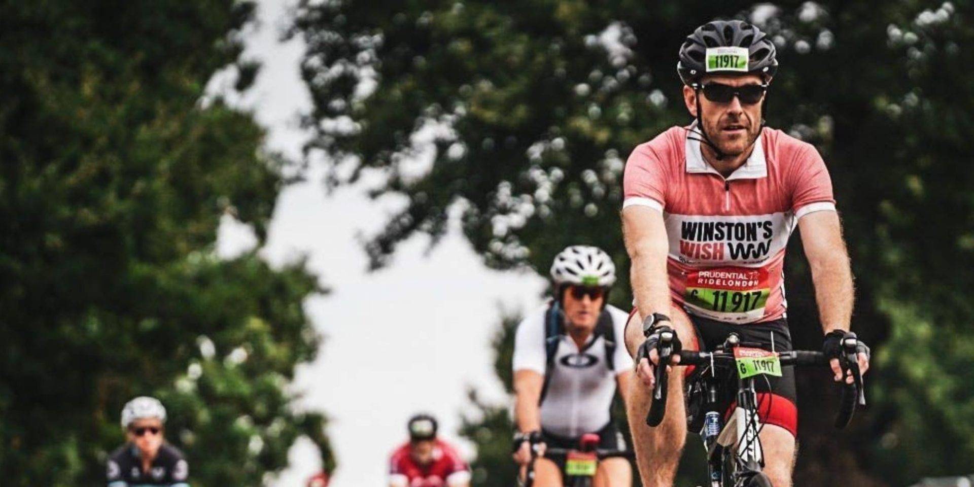 Russ brookes cycling for Winston's Wish in coral jersey