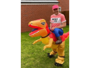 Russ Brookes in inflatable dinosaur costume and running gear in his garden