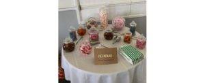 several jars of sweets on a round table with white tablecloth