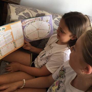 Hattie and Lizzie reading Winston's Wish book Muddles, Puddles and Sunshine