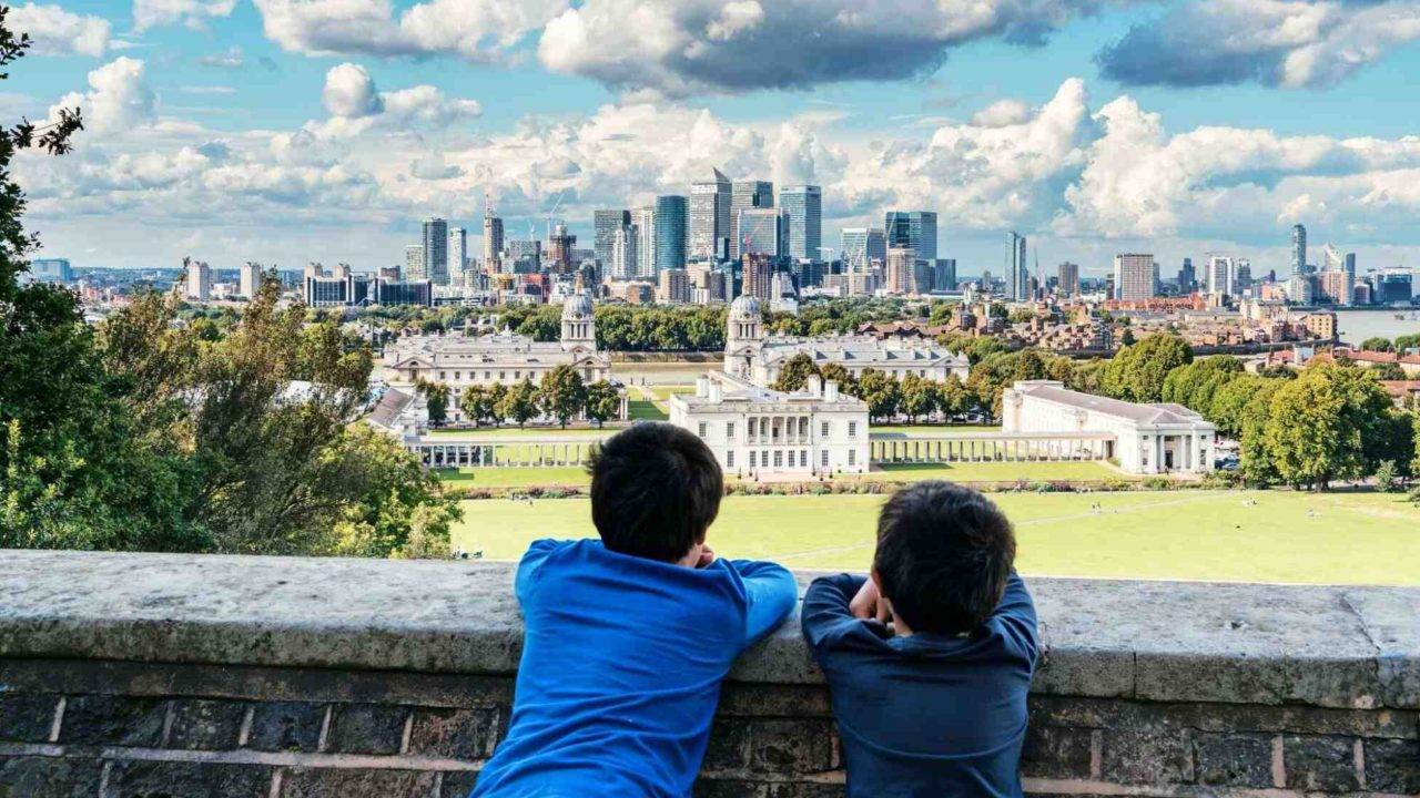 Two young boys looking at a view of Buckingham Palace - How to talk to children about the death of Queen - fas-khan-zydtqCd0T3w-unsplash