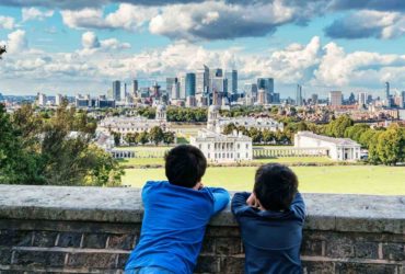 Two young boys looking at a view of Buckingham Palace - How to talk to children about the death of Queen - fas-khan-zydtqCd0T3w-unsplash