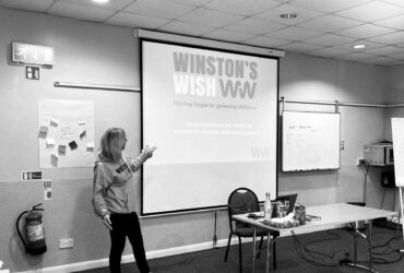 Winston's Wish trainer in front of a projector delivering bespoke bereavement training
