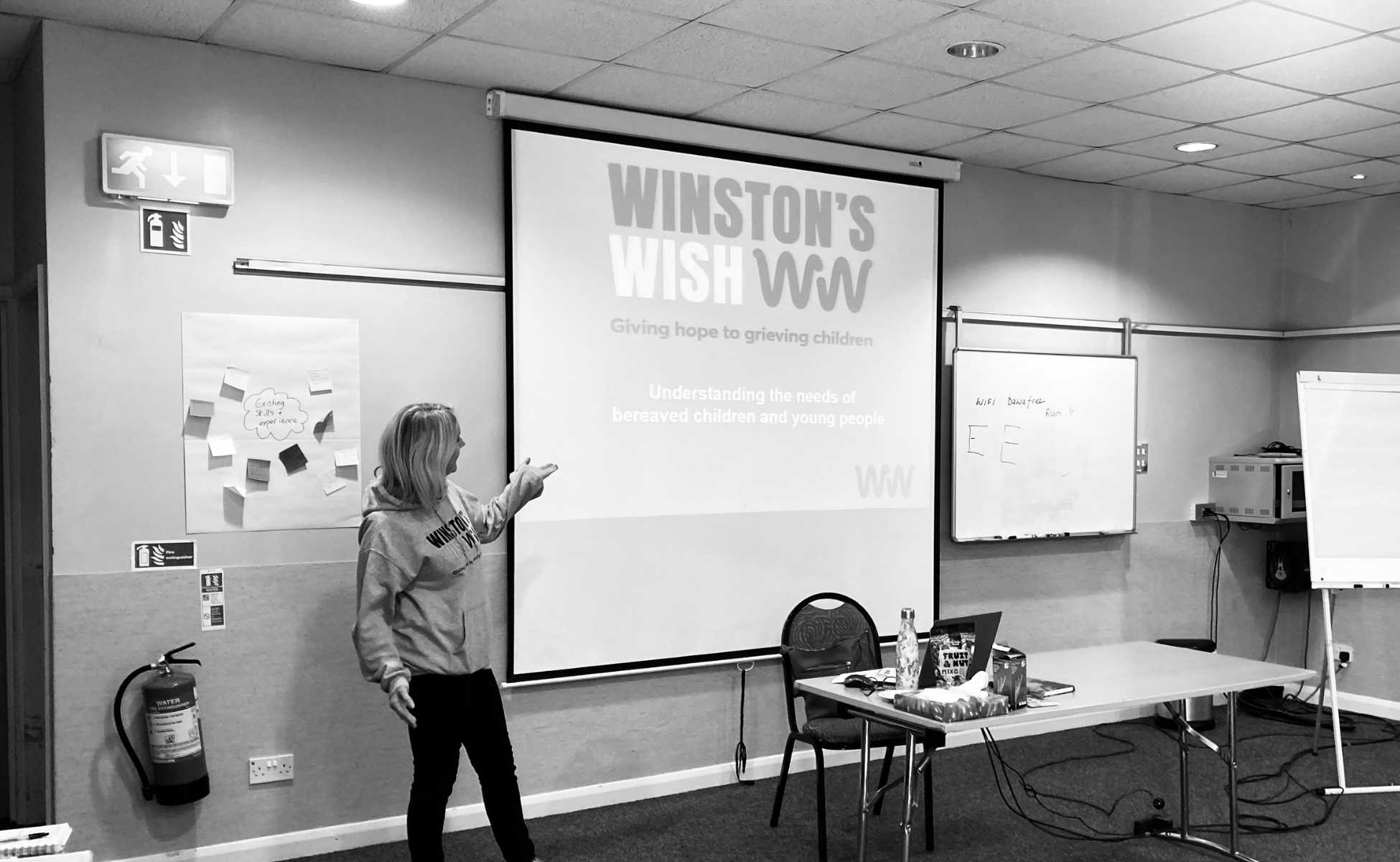 Winston's Wish trainer in front of a projector delivering bespoke bereavement training