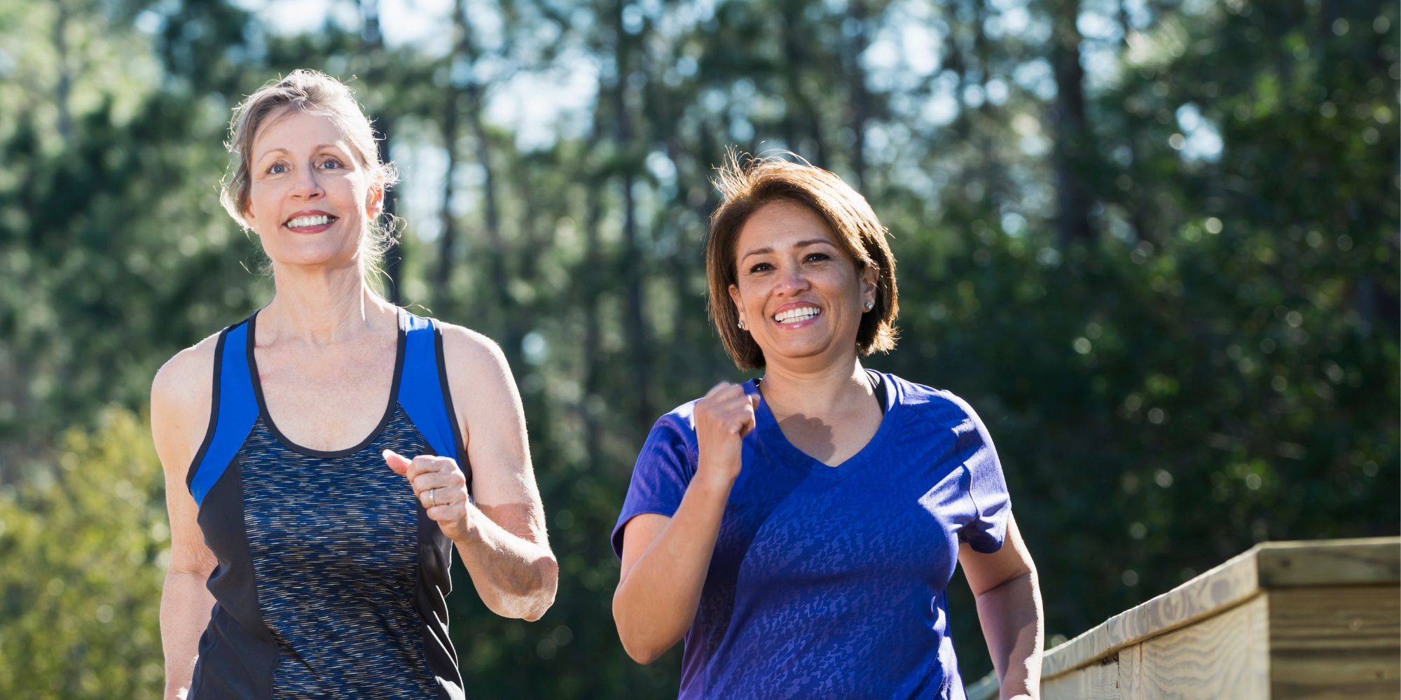 two women smiling and power walking
