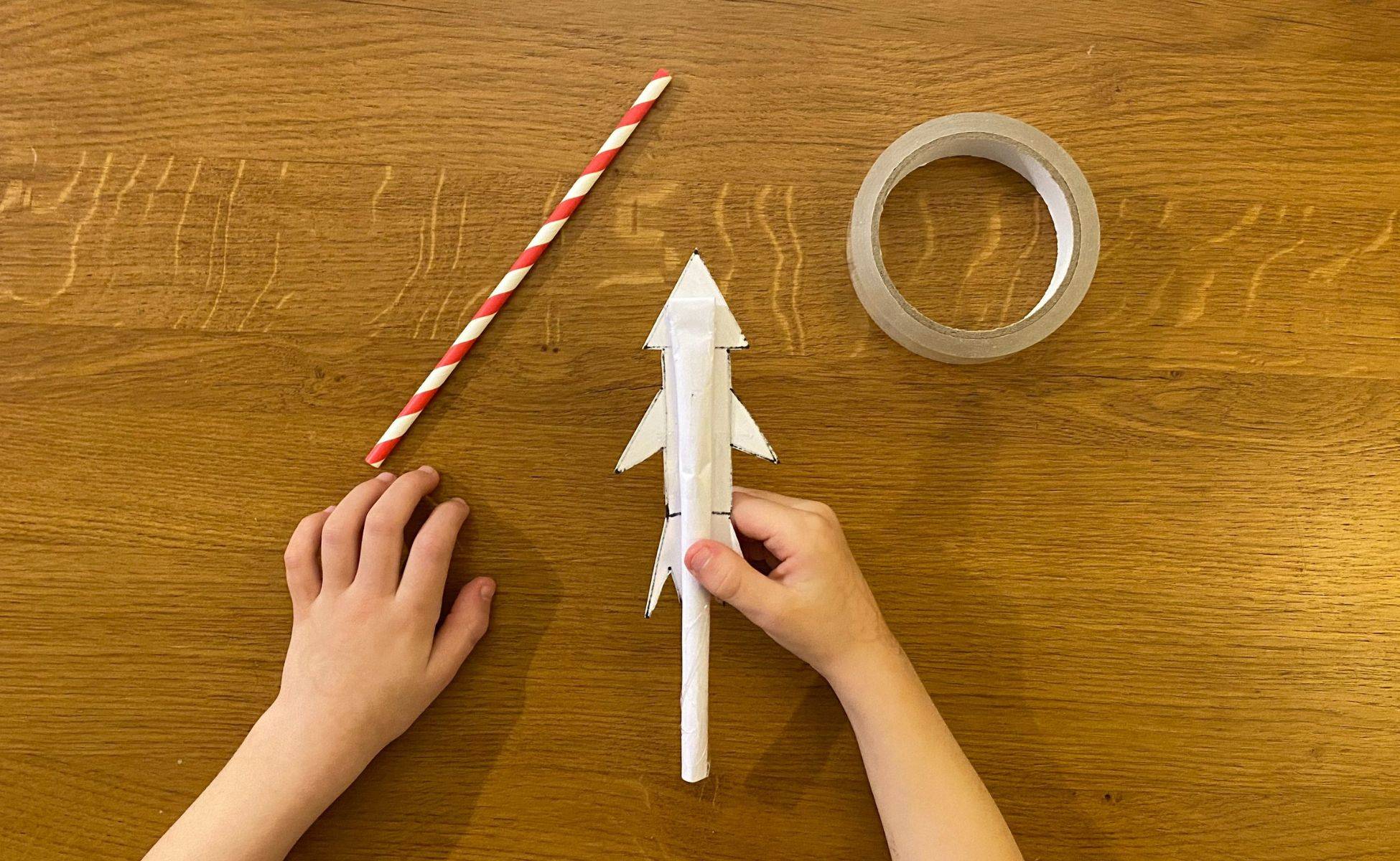 Step 8 With the open end to the bottom tape the tube to the back of the rocket then place your straw in the tube part of the rocket - straw rocket - Winston's Wish