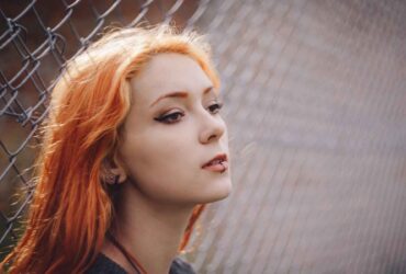 Teenage girl with red hair and a lip ring looking thoughtful - What to say to a young person who is grieving - Winston's Wish
