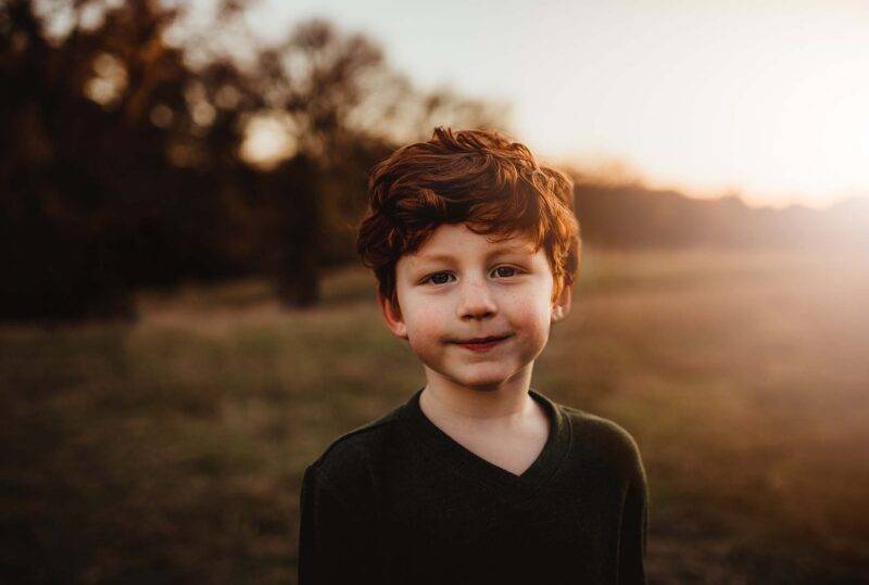 Young boy in a field - get support for grieving children and young people