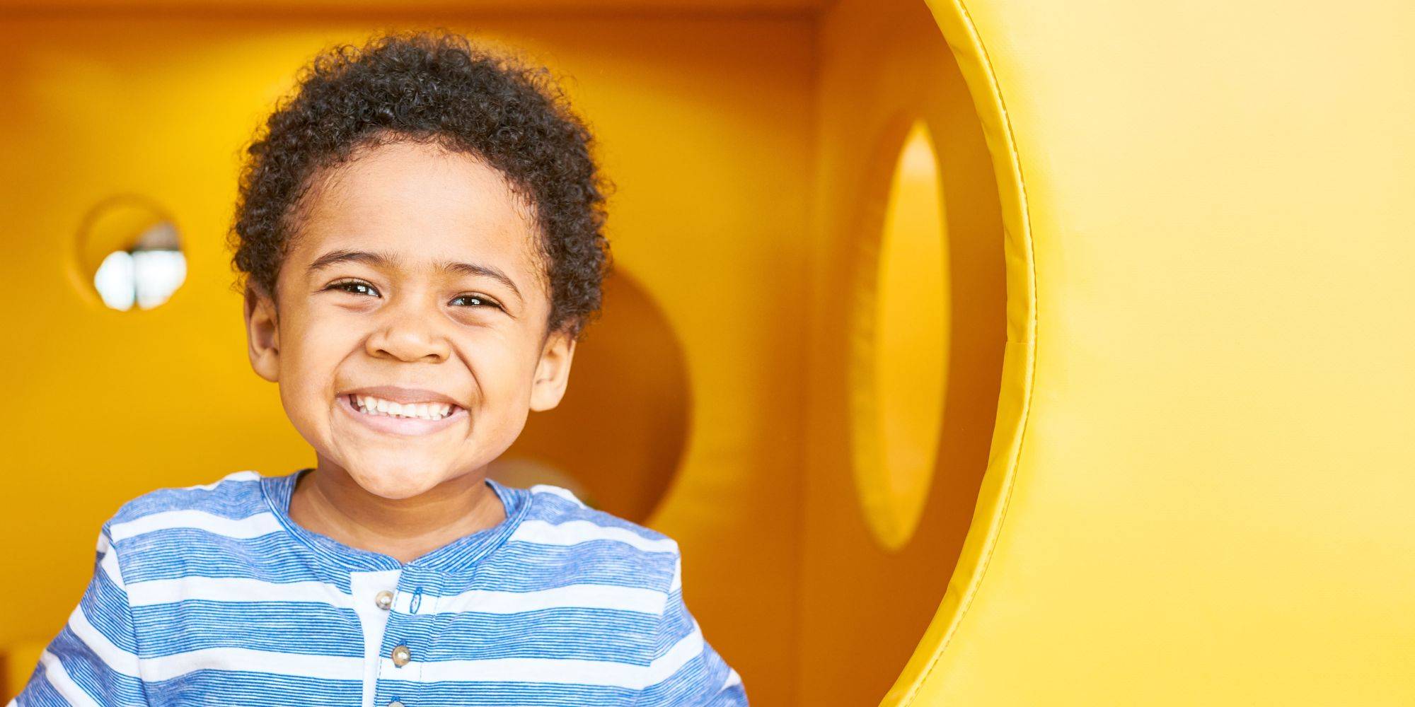 smiling boy with in yellow play area