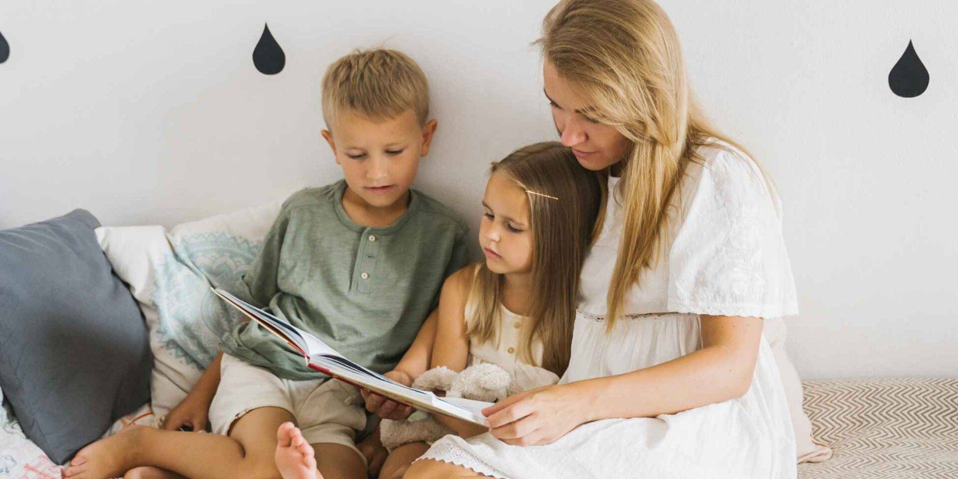 Mum sat reading a book with two children