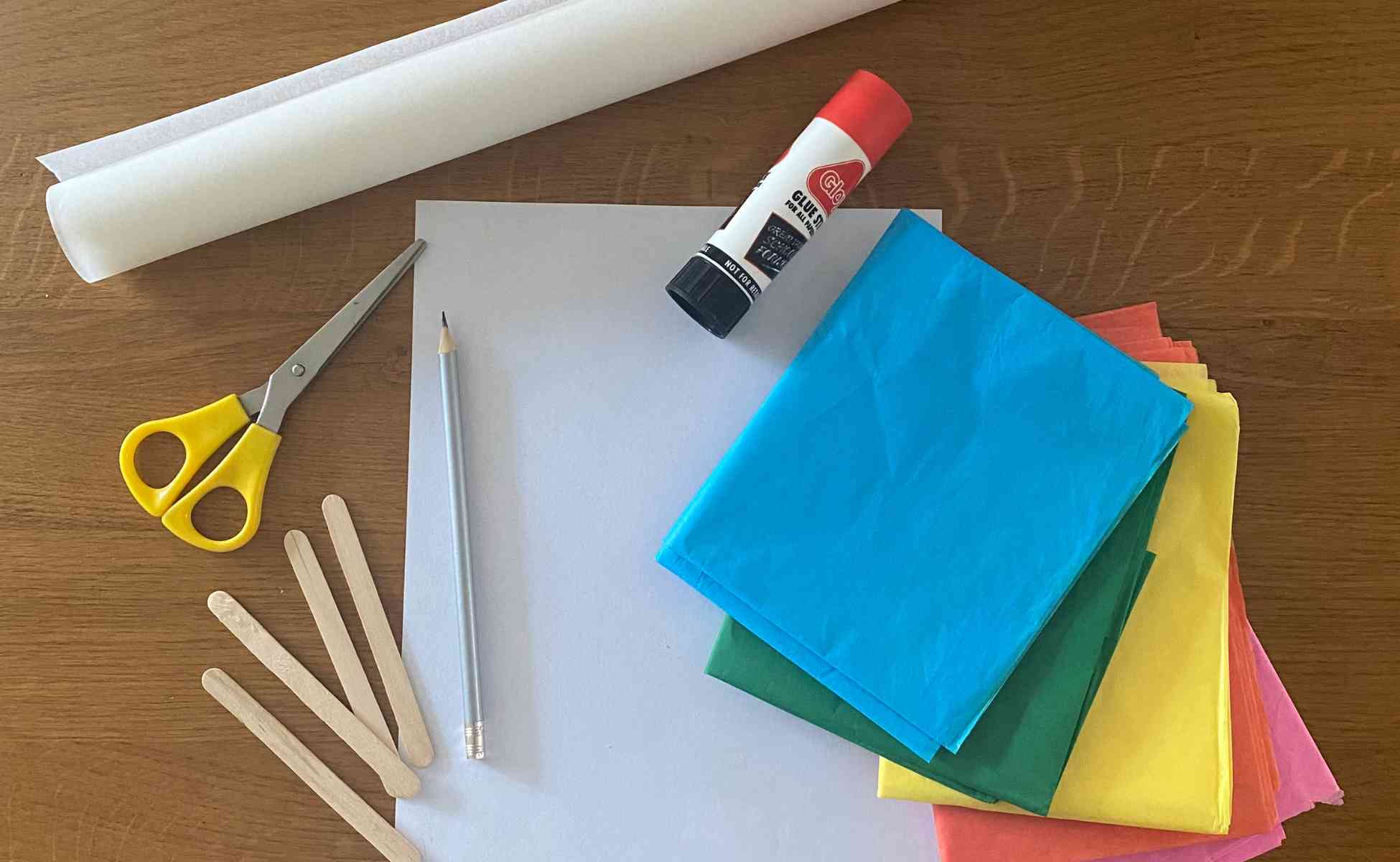 Everything you need for Window Art activity including coloured tissue paper, greaseproof paper, scissors, glue and lollypop sticks.