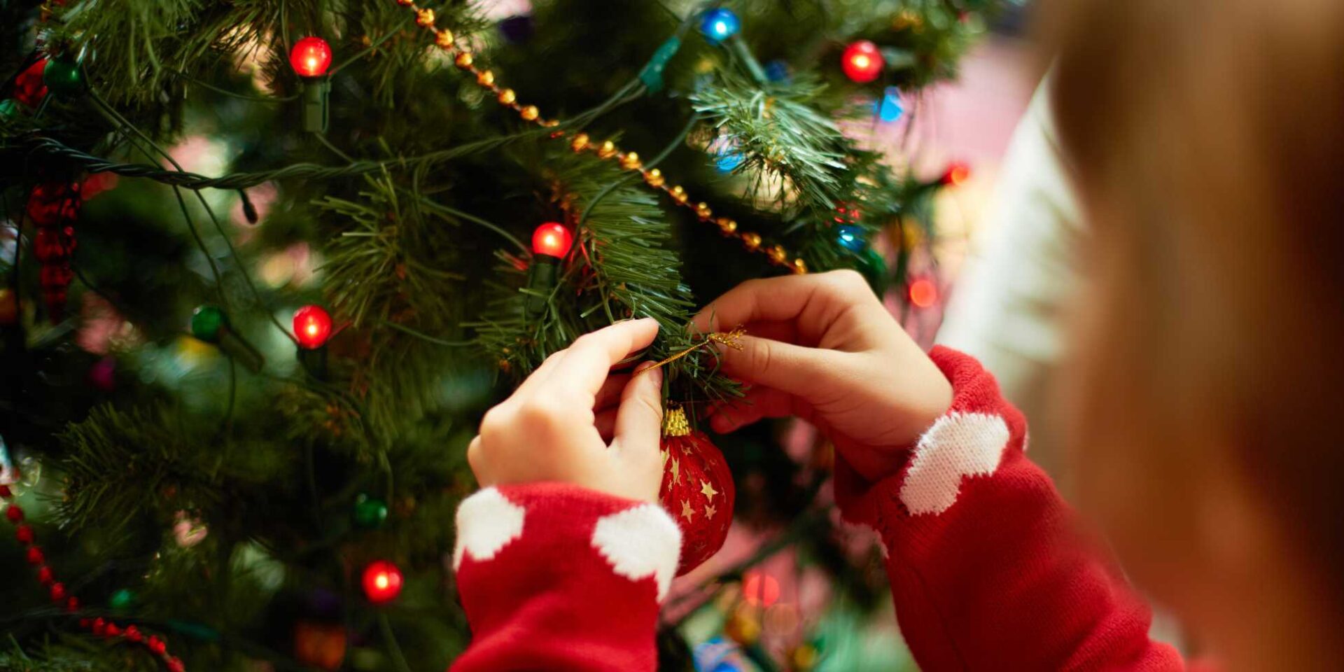 Child's hands putting decorations on a Christmas tree - Winston's Wish