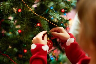 Child's hands putting decorations on a Christmas tree - Winston's Wish