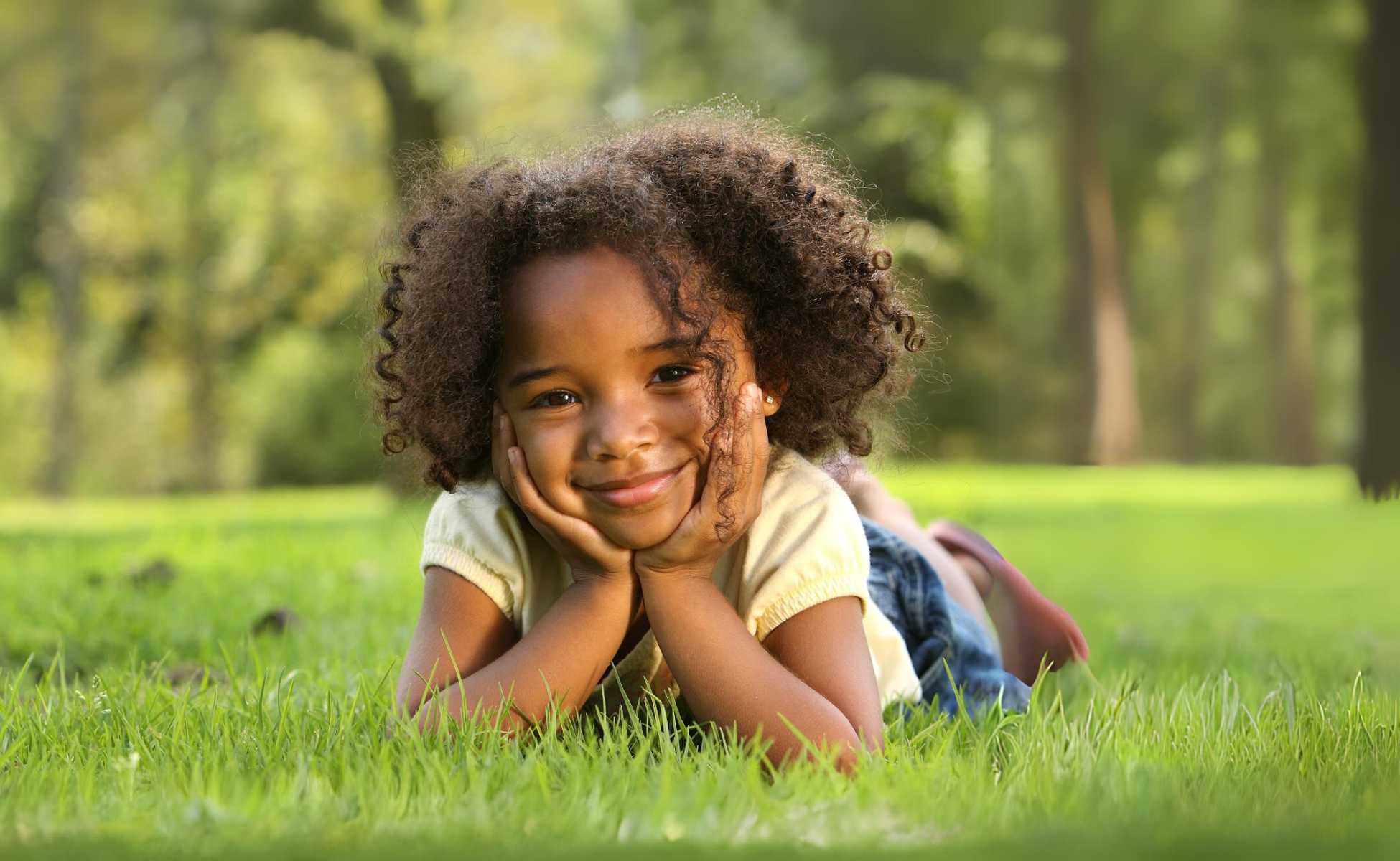 Smiling young girl lying in a field