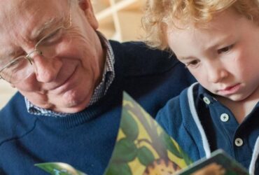 Small child with grandparent reading a picture book