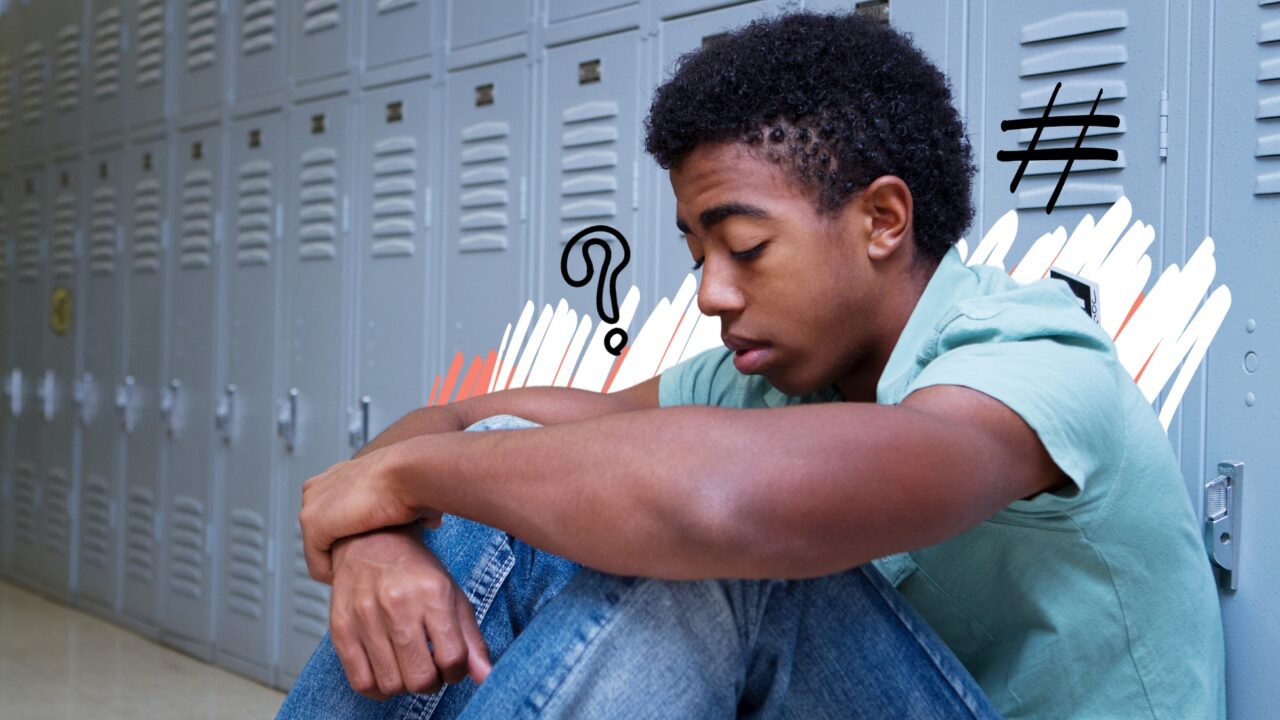 Young male sat beside school lockers, grieving